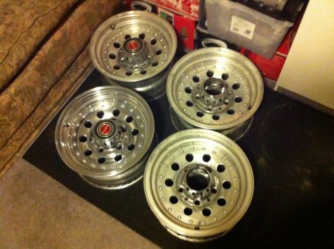 1992 Ford F-150 - Four aluminum wheels are displayed, each a red center cap and a distinctive hole pattern.