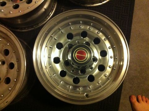 1992 Ford F-150 - A close-up view of a single chrome wheel with a distinctive red and gold center cap.