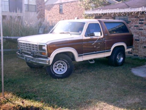 1980 Ford Bronco - This 1980 Ford Bronco features a two-tone paint scheme with brown and cream colors, accented by wood paneling on the rear quarter.