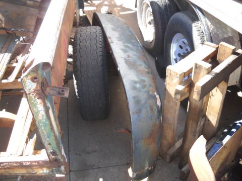 1954 Ford F-100 - A close-up view of a vehicle fender and tire, highlighting their weathered condition and the presence of rust.