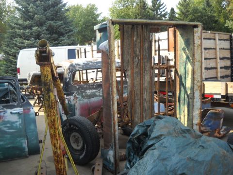 1954 Ford F-100 - A collection of vintage truck parts and a cab sit in an outdoor storage area.