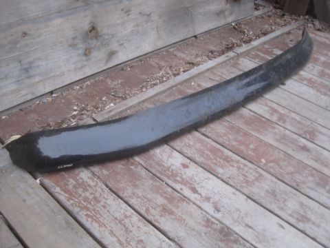1993 Ford Bronco - A black Lund fender flare is shown resting on a weathered wooden deck.