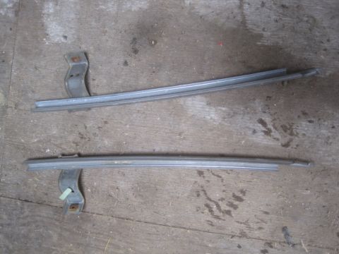 1993 Ford Bronco - Two metal window trim pieces with mounting brackets are shown against a wooden background.