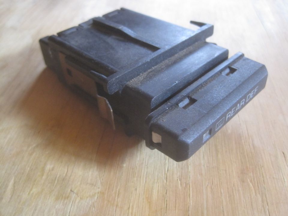 Black rear defogger switch with 'REAR DEF' text