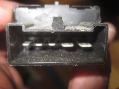 1993 Ford Bronco - This is a close-up view of a dirty electrical connector with several metal pins visible.