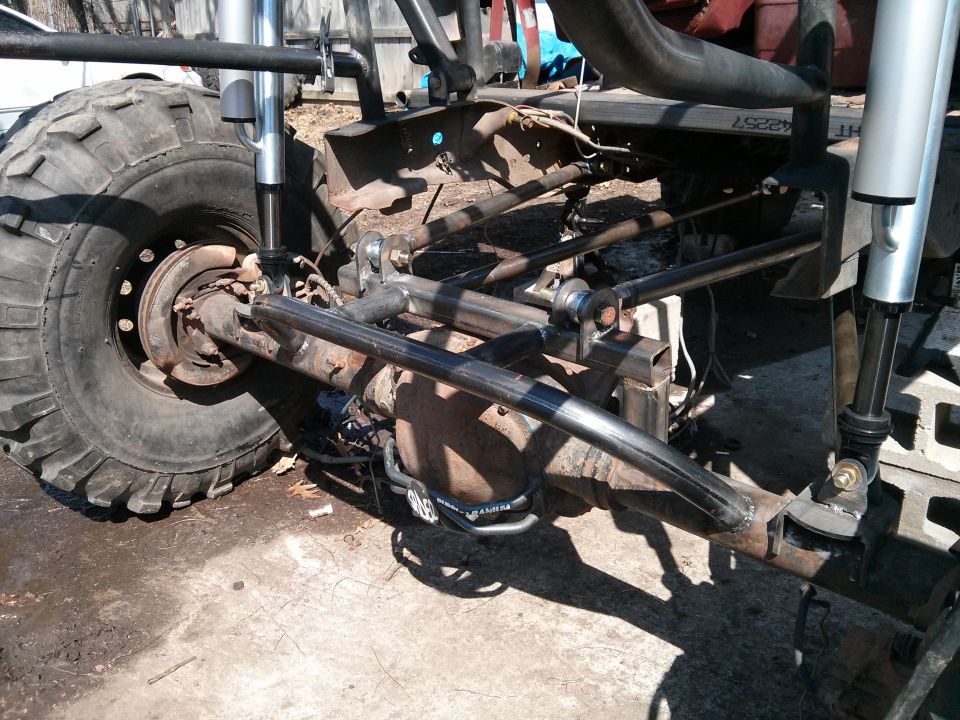 Off-road vehicle chassis with large tire, custom suspension, and roll cage components