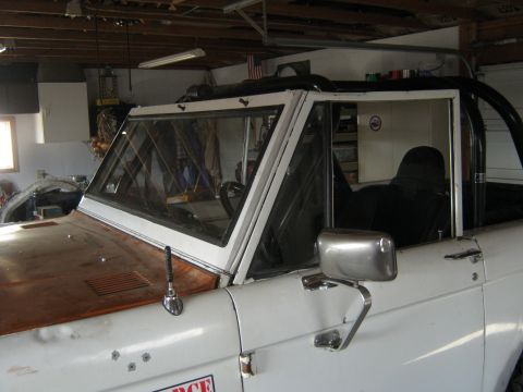 1970 Ford Bronco - The classic 1970 Ford Bronco is shown in a garage setting, highlighting its iconic body style and interior roll cage.