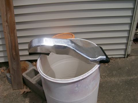 1990 Ford F-150 - A custom aluminum air intake part rests on a plastic bucket near a house.