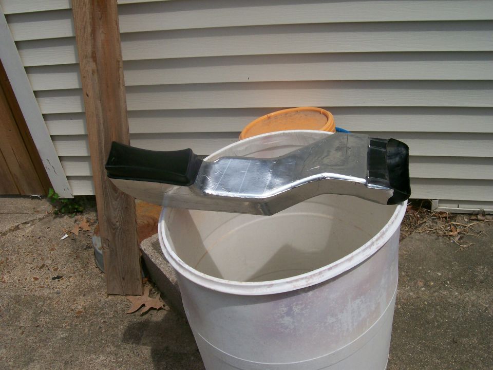 Chrome air intake duct with black end caps resting on a white bucket