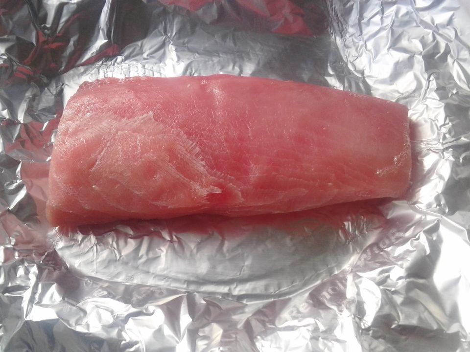 Raw fish fillet on crumpled aluminum foil. Supermotors.net logo in lower right