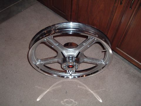 2002 Harley-Davidson Sportster Custom - A chrome motorcycle wheel with a five-spoke design is shown resting on a carpeted floor.