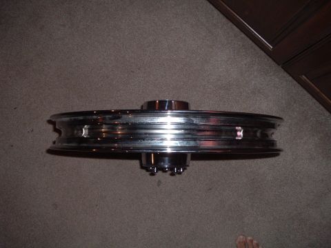 2002 Harley-Davidson Sportster Custom - Chrome motorcycle wheel shown on a carpeted surface.