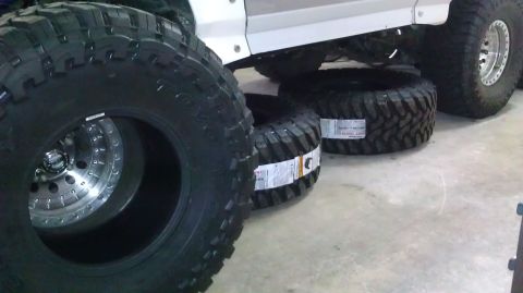 1996 Ford Bronco - New off-road tires are staged around a vehicle, ready for installation.