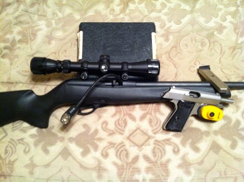 2005 Ford Crown Victoria - A rifle with a scope and a handgun are displayed together, along with a magazine and a yellow trigger lock.