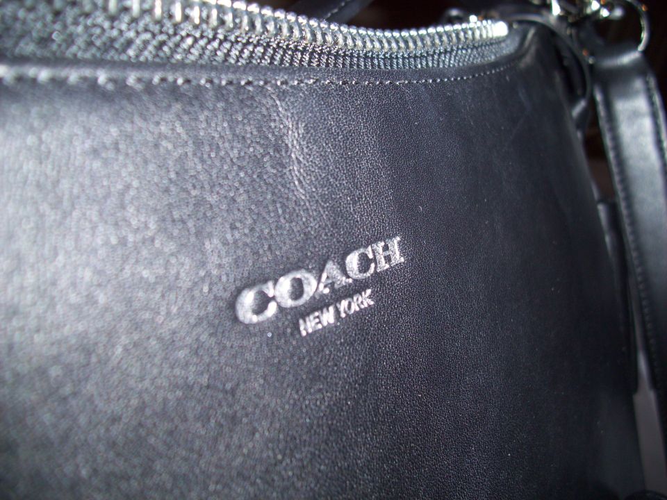 Black leather handbag with silver COACH NEW YORK logo and zipper detail