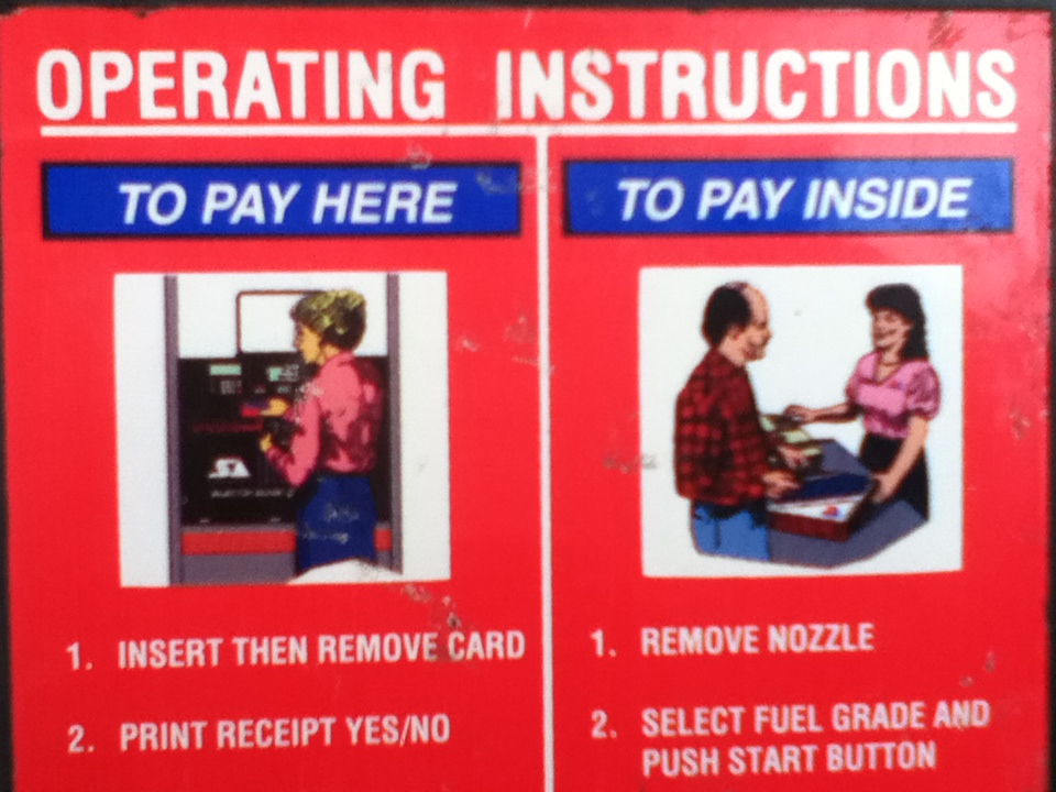 Red sign with white text 'OPERATING INSTRUCTIONS' and two sections: 'TO PAY HERE' with an image of a person using a payment kiosk, and 'TO PAY INSIDE' with an image of a person paying at a counter