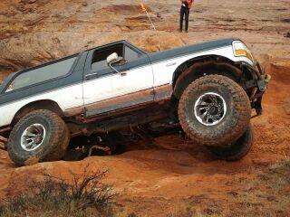 1994 Ford Bronco - An SUV navigates a challenging off-road terrain, demonstrating its suspension capabilities.