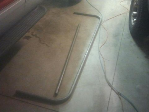 1994 Ford Bronco - A metal trim piece is on the floor, possibly a car part.