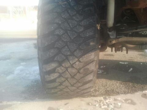 1994 Ford Bronco - This image shows a close-up view of a vehicle's tire and suspension system, with snow on the ground.