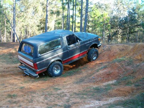1991 Ford Bronco - This lifted Ford Bronco navigates a challenging dirt terrain.