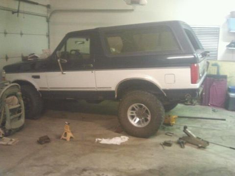 1994 Ford Bronco - This 1994 Ford Bronco is parked inside a garage, showing its distinctive two-tone paint scheme.
