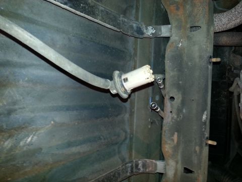 1994 Ford Bronco - Underside view of a vehicle's fuel filter assembly, showing a hose and metal lines connected to the frame.