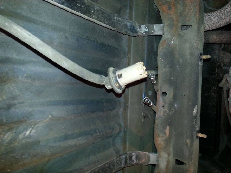 Fuel filter assembly with hose and metal lines attached to vehicle frame
