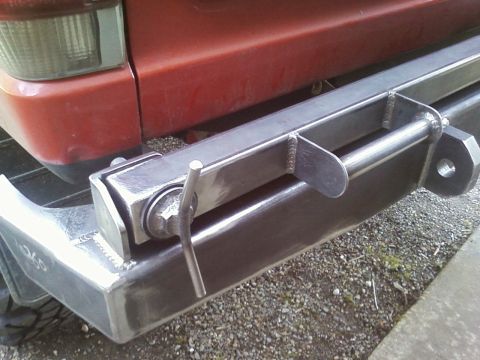 1989 Ford Bronco - A custom metal bumper and hitch receiver are attached to the rear of a red vehicle.