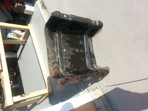 1994 Ford Bronco - This heavily rusted metal component is shown outdoors, resting on a paved surface.