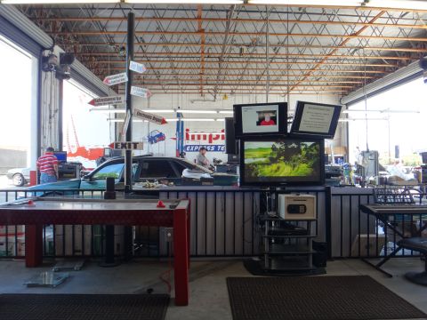 1993 Ford Taurus - Interior view of a car in a service bay with a man working at a computer station.