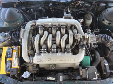 1993 Ford Taurus - The engine bay of a 1993 Ford Taurus SHO, clearly showing the "SHO 24 VALVE DOHC" labeling on the intake manifold.