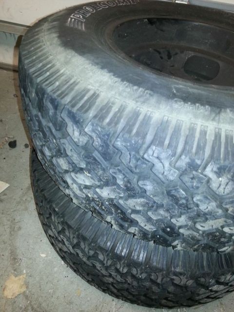 1987 Toyota 4Runner - Two off-road tires are stacked, with the brand "PRO-COMP" visible on the upper tire's sidewall.