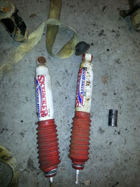 1987 Toyota 4Runner - Pair of Skyjacker Nitro shocks with red bellows and a metal sleeve on concrete.