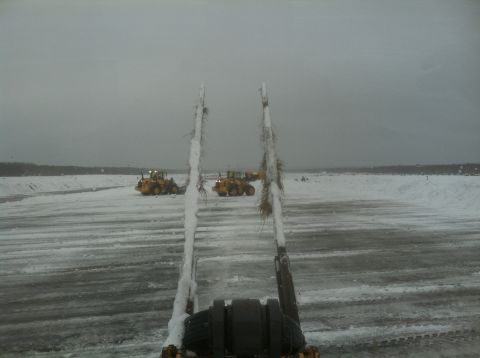 2011 Volvo V90 - Two yellow wheel loaders are seen in a wide, snowy landscape, suggesting a work or maintenance operation.