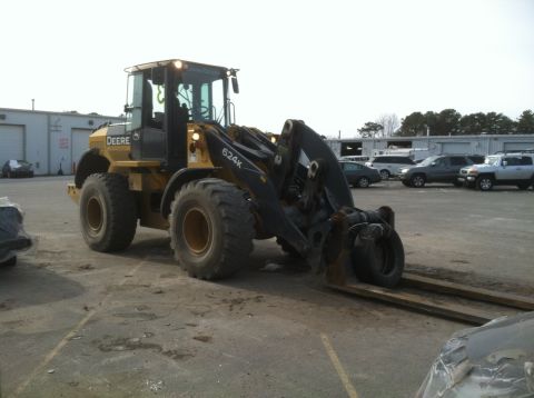 2011 Volvo V90 - A yellow John Deere 624K wheel loader is parked in an outdoor lot with buildings in the background.