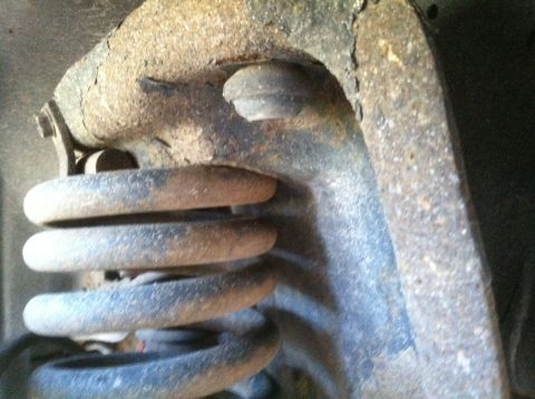1989 Ford Bronco - This image shows a heavily rusted suspension spring and control arm, not a complete vehicle.
