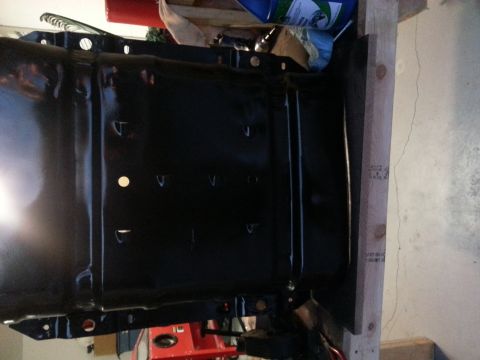 1994 Ford Bronco - A black metal component, possibly a fuel tank, is shown mounted on wooden supports.