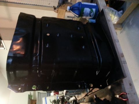 1994 Ford Bronco - A black metal fuel tank is shown, likely for a vehicle, with visible mounting holes and brackets.