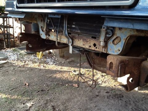 1989 Ford Bronco - The front frame and bumper mounts of a vehicle show significant rust and damage.