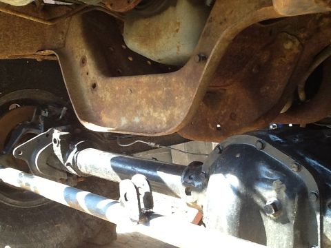 1989 Ford Bronco - The undercarriage of a vehicle shows significant rust on the frame and suspension components.