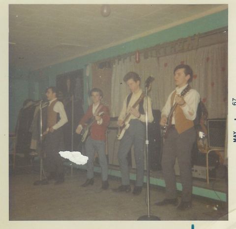 1963 Ford Galaxie - A band performs on stage, with four members playing guitars and one singing into a microphone. The photo is dated May 1967.