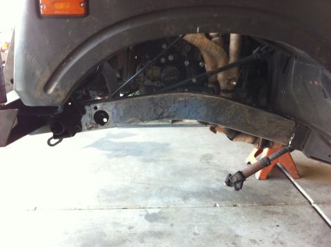 1987 Suzuki Samurai - Front axle and suspension components of a Suzuki Samurai are visible, supported by jack stands.