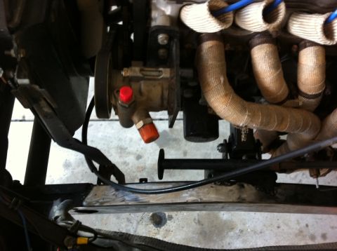 1987 Suzuki Samurai - Close-up view of engine components, including the exhaust manifold wrapped in heat tape, and part of the power steering pump.