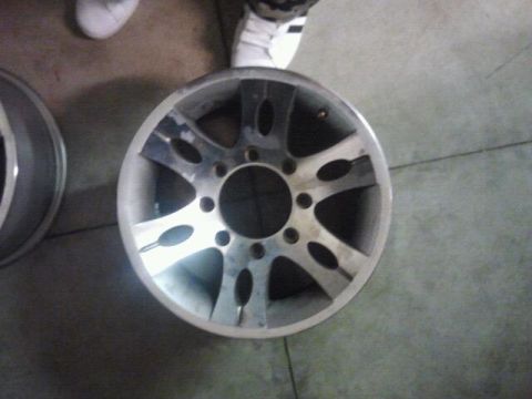 1994 Ford Bronco - A single alloy wheel is shown, with another wheel partially visible. The wheels are on a concrete floor.
