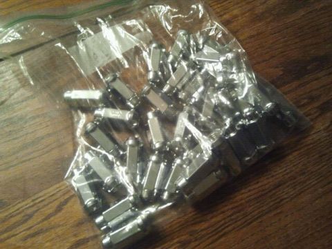 1994 Ford Bronco - A plastic bag filled with numerous chrome lug nuts sits on a wooden table.