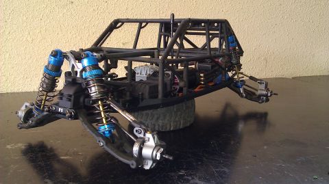 1996 Ford Bronco - The chassis of an RC car is shown from a three-quarter front angle, highlighting its suspension and roll cage.