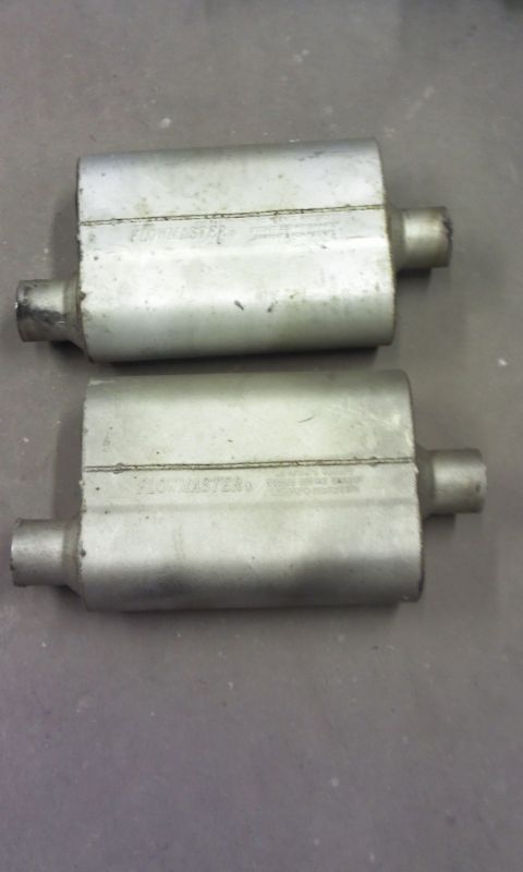 1967 Ford F-100 - Two Flowmaster exhaust mufflers are shown, one above the other, on a gray surface.