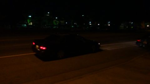 1993 Ford Taurus - Two vehicles on a road at night, one in the foreground and another further back.