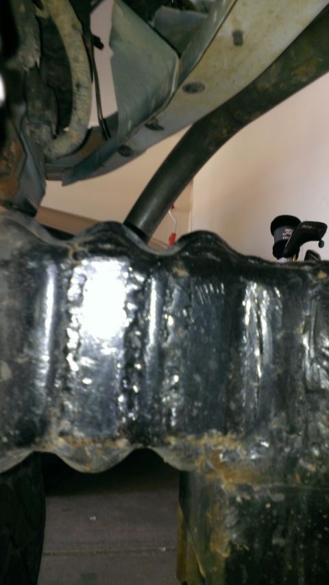 1994 Ford Bronco - Close-up view of the undercarriage, focusing on the frame and suspension parts. A website logo is present.