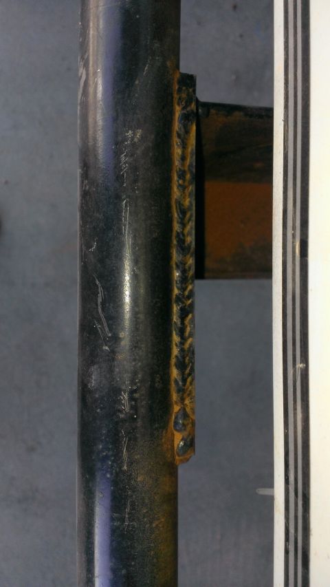 1994 Ford Bronco - Close-up view of a welded metal pipe with a visible braided seam and a bracket.